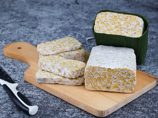 Sliced of Tempeh or tempe on cutting board. Tempeh is a traditional Indonesian food made from fermented soy beans. 