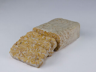 Sliced of Tempeh or tempe isolated on white background . Tempeh is a traditional Indonesian food made from fermented soy beans. 