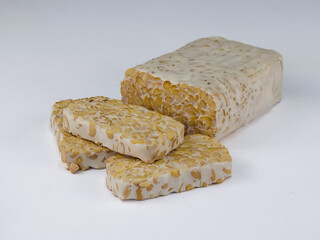 Sliced of Tempeh or tempe isolated on white background . Tempeh is a traditional Indonesian food made from fermented soy beans. 