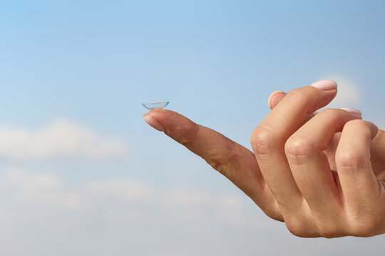 Contact lens on fingertip with blue sky background