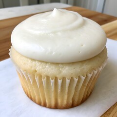 Delicious vanilla cupcake with creamy white frosting close up