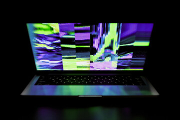 Neon Glitch on Laptop Screen in Dark Room