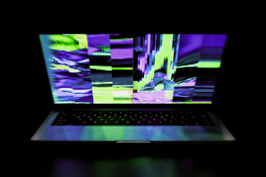 Neon Glitch on Laptop Screen in Dark Room