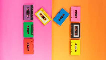 Colorful Cassette Tapes on Contrasting Bright Pink and Orange Background