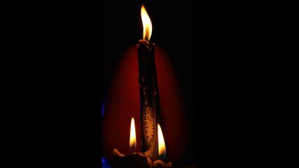 Three black candles in the dark. Flame of black candles.Magic and esotericism. Flame of black candles in the dark. Atmospheric magic. 4k footage - Powered by Adobe