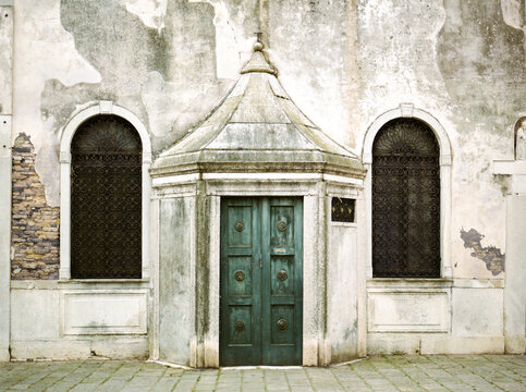 Ancient church's carved wooden door and arched windows