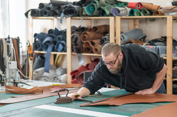 Caucasian bearded man working as a tanner in a workshop. 
