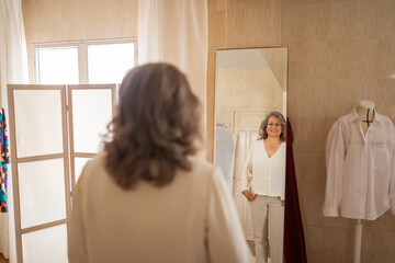 Senior client checking shirt fit in fashion workshop