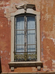 Old window in a building in Albufeira, traditional style, shutters are closed and appear to be made...