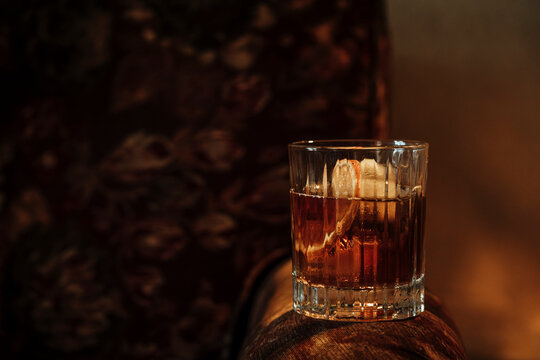 Cozy Moment With a Drink on a Vintage Armchair in Dim Light