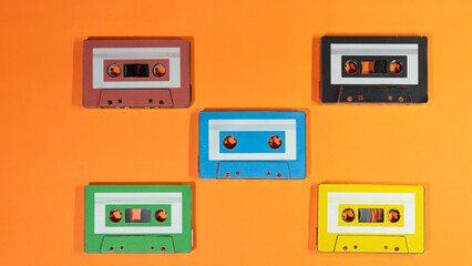 Colorful Vintage Audio Cassettes Arranged on Bright Orange Background