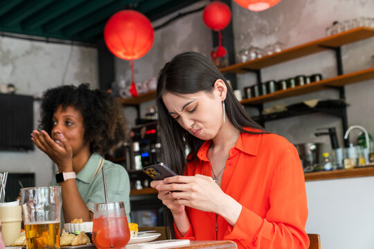 Woman reacting to phone at cafe