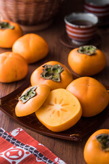 【庄内柿 / ひらたねなし柿】秋の味覚。橙色に色づいた柿の実。種がなく扁平な形。甘くて美味しい山形県庄内地方の特産品。