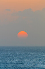 The orange sun sets over the ocean in Barbados