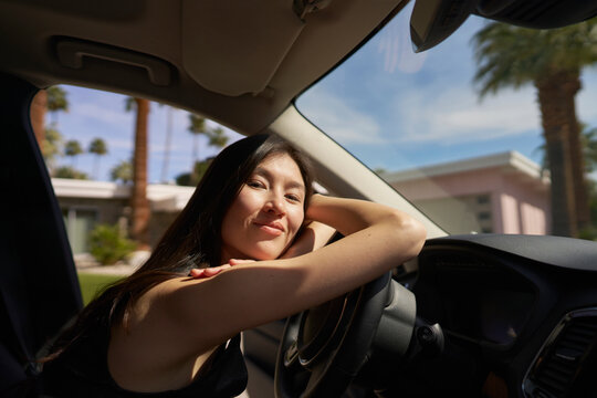 Woman Enjoying a Sunny Day Inside Car With Palm Trees