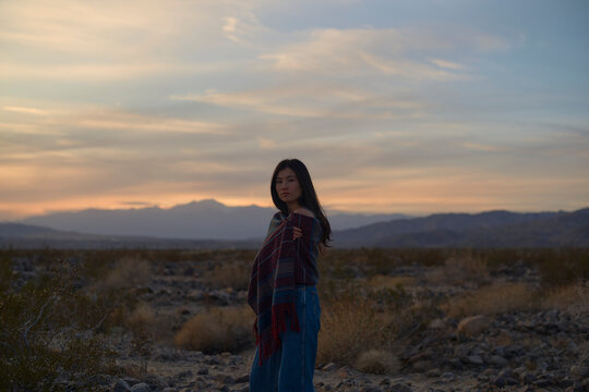 Young Woman Gazing Into the Sunset in a Desert Landscape