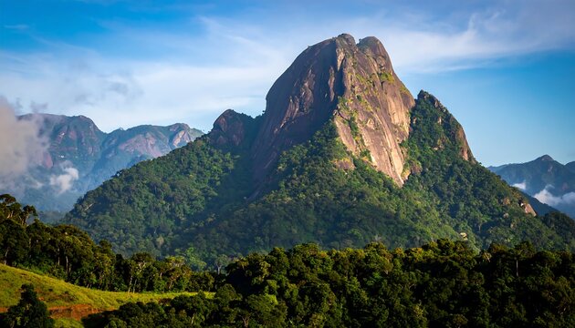 Rocky peak rises above lush green valley