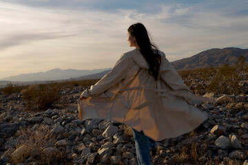 Woman Enjoying a Breezy Moment in the Desert at Sunset