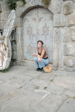 young woman sitting by aport int he city of Porto, Portugal