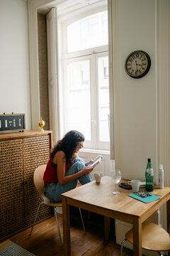 young woman sitting at table in apartment 