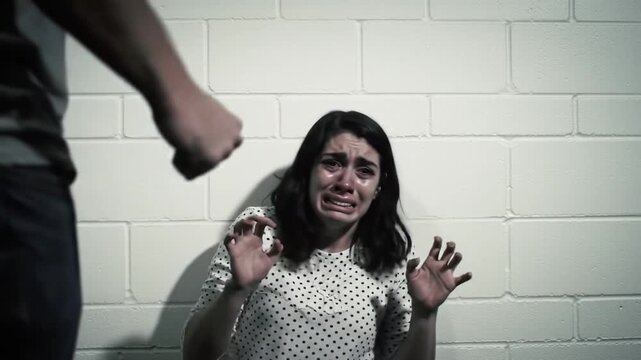 Crying Woman Defending Herself From Aggressor in Dark Moody Indoor Setting