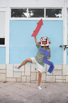 Woman dressed robot mask with cardboard  zigzag and arrow 