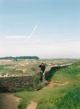 Man sits on ancient stones wall