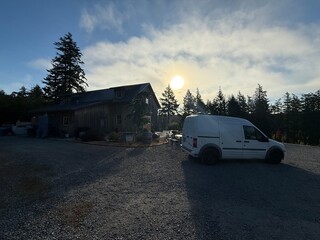 Barn-style building and white van at sunset