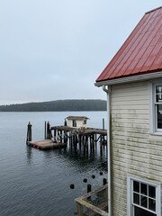 Old dock and small building on pilings by water