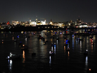 Reflections on the river water of lights from the boats anchored in preparation for the night show