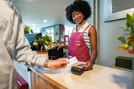 Florist processing credit card payment at garden center checkout