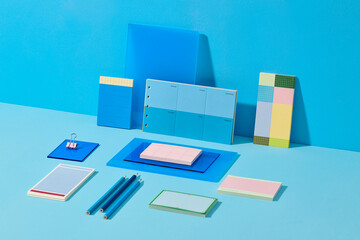 Various blue stationery items, including notebooks and pens on blue