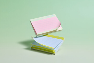 Floating pastel notepads against a soft green background