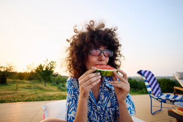 Woman eats a slice of watermelon