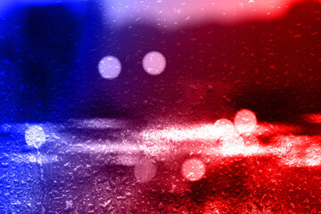 Police red and blue lights in city, blurred view through wet glass