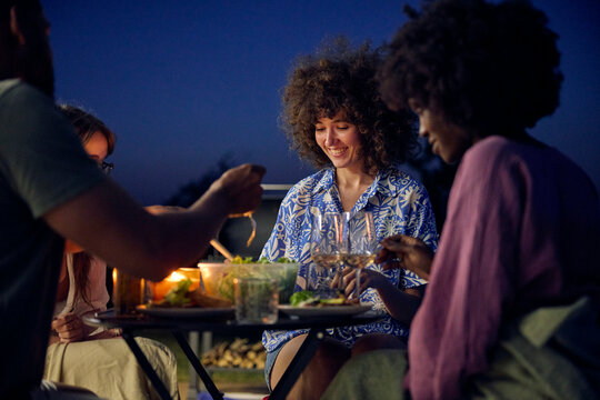 Group of friends enjoy dinner on the porch