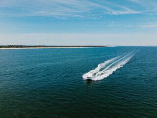 Bright Sunny Day With a Boat Cruising on Calm Blue Waters