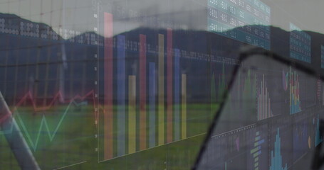 Displaying transparent digital dashboard covering field, with bar and line charts, numeric panels