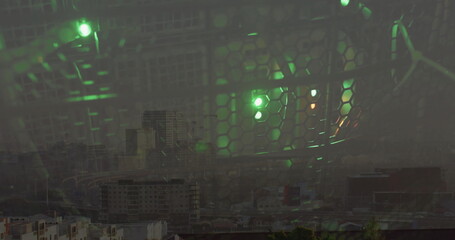 Showing hexagonal metal mesh barrier glowing with green LED lights at rooftop, viewing city skyline
