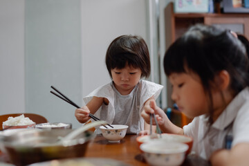 Child learn using chopsticks at home 