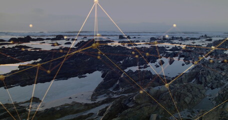 Showing rocky outcrops, tide pools holding reflective water at shore, with golden nodes and lines