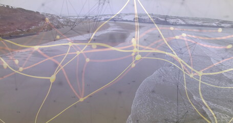 Animating overlay network of glowing nodes and lines across coastal bay with sandy shoreline