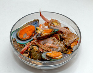 Freshly prepared seafood assortment pile inside glass bowl isolated on white
