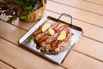 Hot cakes or pancakes with maple syrup, butter, and fruit