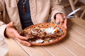 man in a restaurant eating chilaquiles with ribs