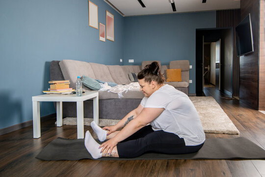 Plus size young woman doing yoga at home