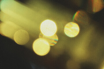 Abstract blurred yellow, green bokeh lights and hues upper-left corner, Grainy overlay on black background © Uuganbayar