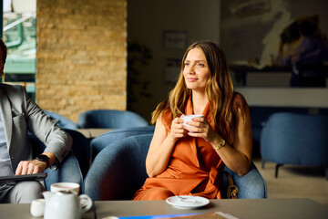Woman drinks coffee in the hotel lobby