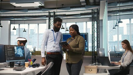 Startup office coworkers doing brainstorming, developing artificial intelligence models for business analytics. Team of engineers running simulations for AI driven forecasting, camera A