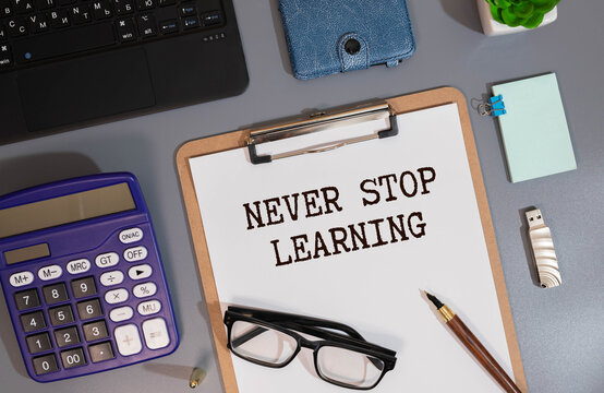Never stop learning written on a memo stick. Lifelong learning concept
